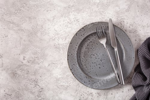 Preview: empty plate fork knife on concrete background