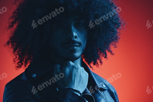 Preview: Portrait of fashion man with curly hair on red background multinational, colored light, black