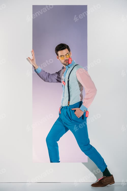 Preview: handsome man in stylish clothes with sale tags standing in frame on white