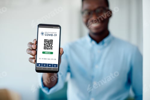 Preview: Close-up of African American man showing COVID-19 immune digital health passport on smart phone.