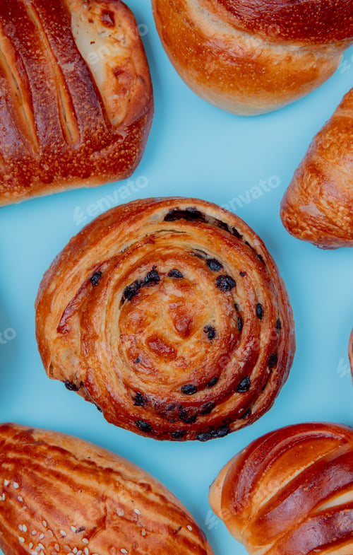 Preview: top view of bakery products as french pastry bun roll, croissant, brioche on blue background