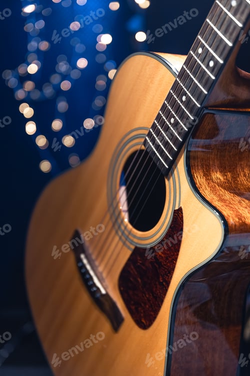 Preview: Close-up, acoustic guitar on a dark background with bokeh lights.