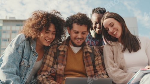 Preview: Happy smiling friends laughing outside at something in a laptop