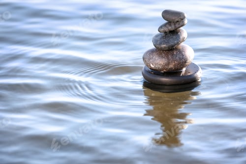 Preview: Stack of dark stones in sea water, space for text. Zen concept