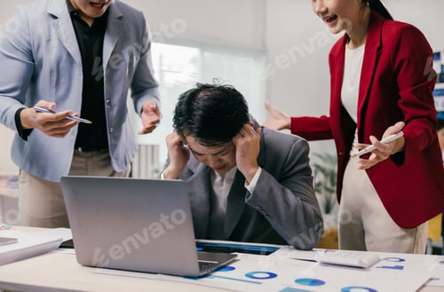Preview: Exhausted asian businessman covering ears with hands suffering from headache caused by angry colleag