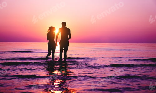 Preview: Silhouette of couple in love running inside ocean water at sunset