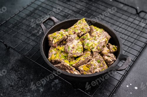 Preview: Oriental Halva with pistachio in a skillet. Natural vegan sweets. black background. top view.
