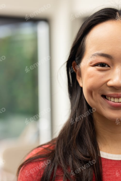 Preview: Smiling young asian woman with long hair, wearing red shirt, looking at camera, copy space