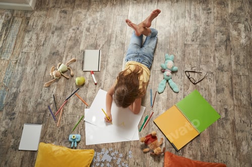 Preview: Creative hobbies for kids. Top view of little caucasian girl lying on the wooden floor