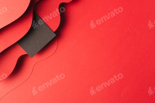 Preview: Square of black paper with copy space on red waves of paper on red background