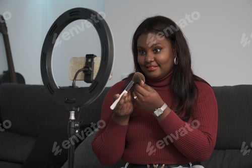 Preview: Happy young cuban woman making online product review at home.