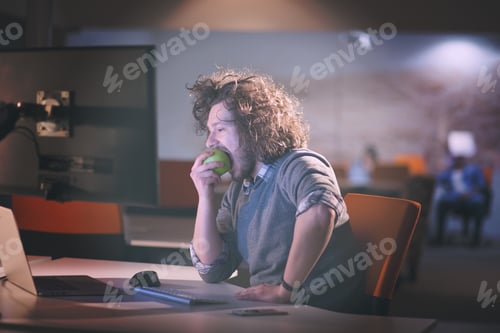 Preview: man eating apple in his office