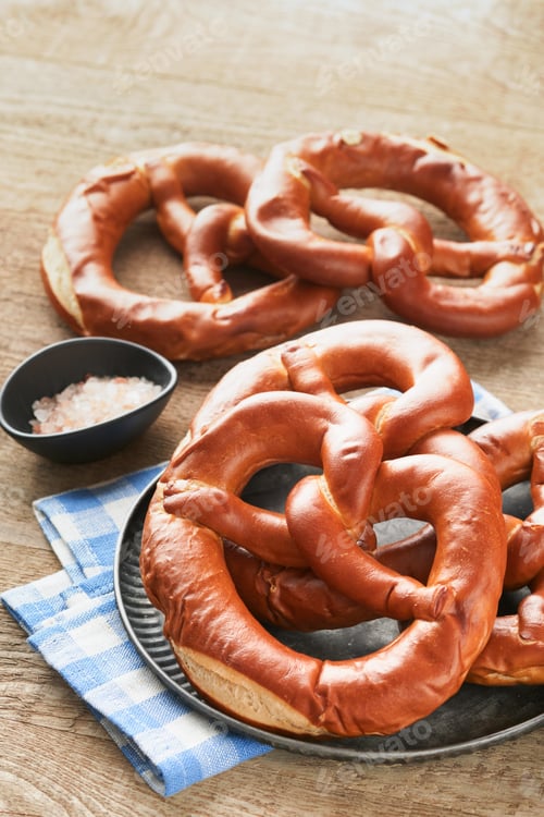 Preview: Oktoberfest concept card. Traditional Bavarian pretzels with beer bottle mug on old rustic wooden ba