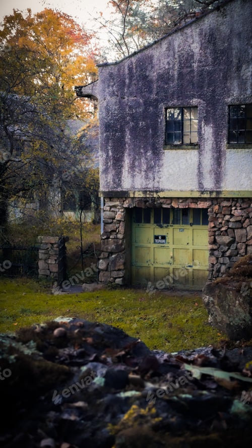 Preview: Abandoned building with a stone foundation and green garage door