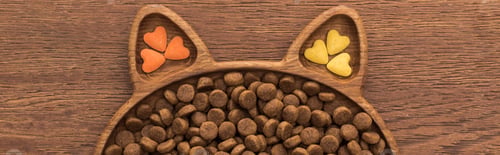 Preview: top view of feline dry pet food and vitamins in cat shape plate on wooden table, panoramic shot