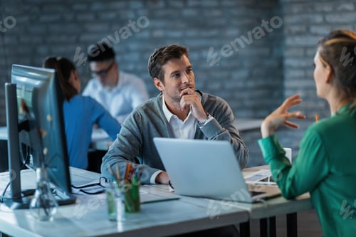 Preview: Smiling financial advisor listening his client during the meeting in the office.