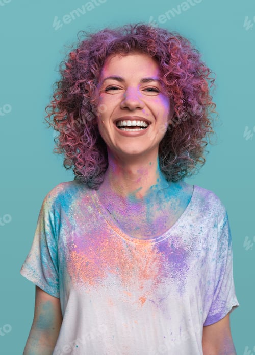 Preview: Laughing young woman with colorful Holi paints