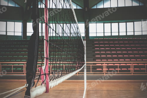 Preview: Volleyball net stands tall in empty gymnasium, ready for the game