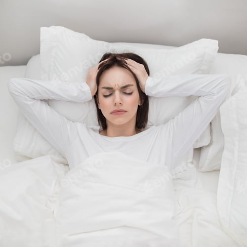 Preview: Top view of unhappy woman lying in bed, have headache