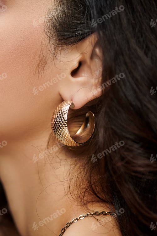 Preview: Young woman adorned with stylish jewelry poses against a vibrant backdrop