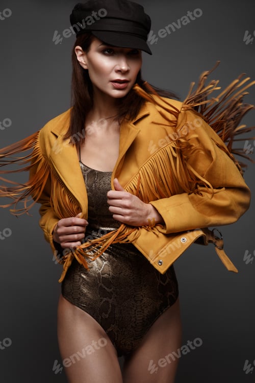 Beautiful girl with a classic make-up and a hairstyle in a fashionable designer jacket and cap