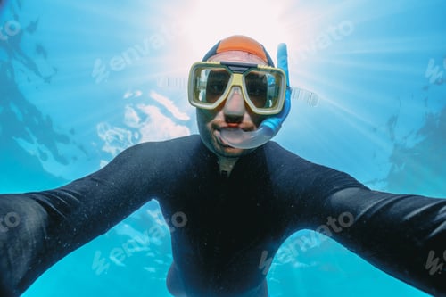 Preview: men using a stinger suit in the great barrier reef in summer time .