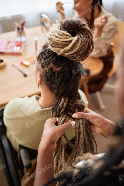 Preview: Woman Braiding Hair of Friend in Wheelchair at Home