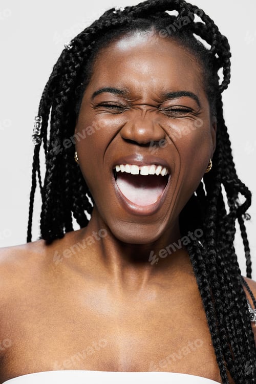 Preview: Happy black woman with braids joyfully laughing against a light background, embodying positivity and