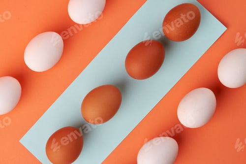 Preview: Top view composition of chicken eggs on a blue paper.