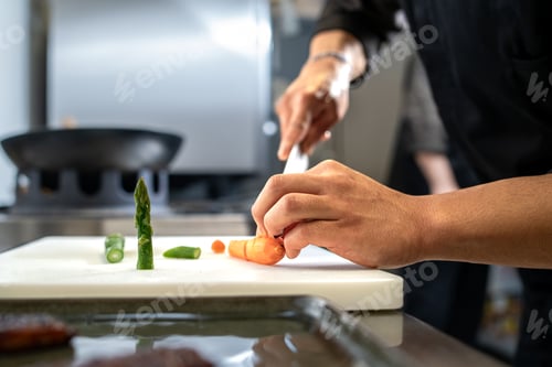 Preview: Chef slicing vegetables with knife on cutting board in kitchen preparation