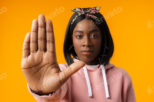 Preview: Young african woman over yellow background doing stop sign with palm of the hand