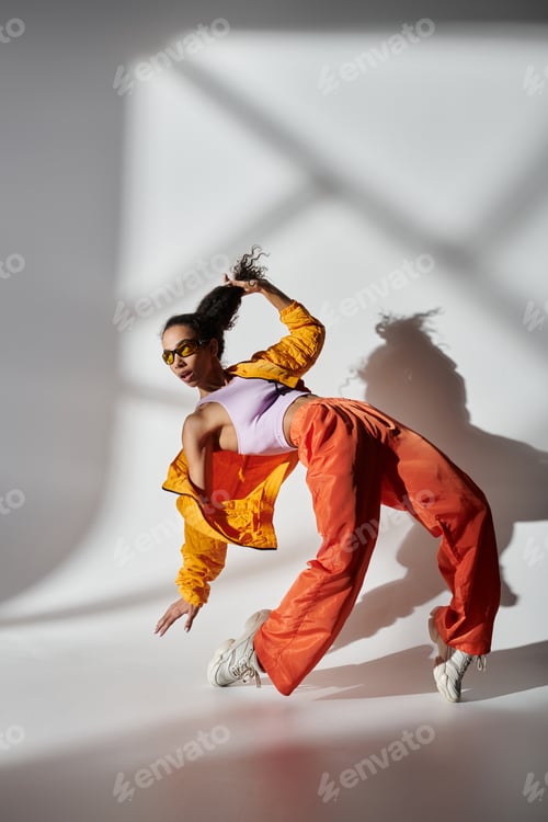 Preview: Stylish woman in yellow jacket and orange pants