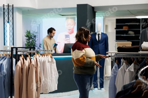 Preview: Woman selecting clothes in boutique
