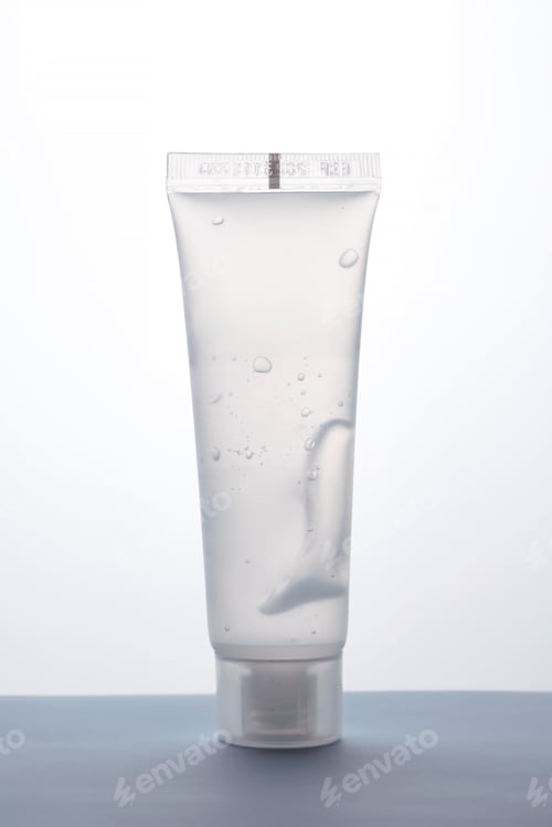 Visualização: Frasco transparente de gel cosmético em um fundo branco.