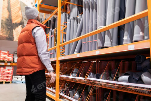 Preview: a man in a plumbing store chooses plumbing plastic pipes for sewage inside the house