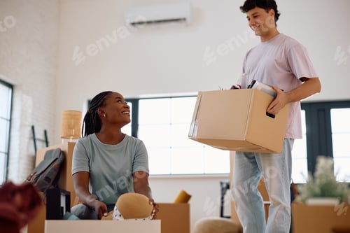 Preview: Young happy couple unpacking their belongings while moving into new apartment.