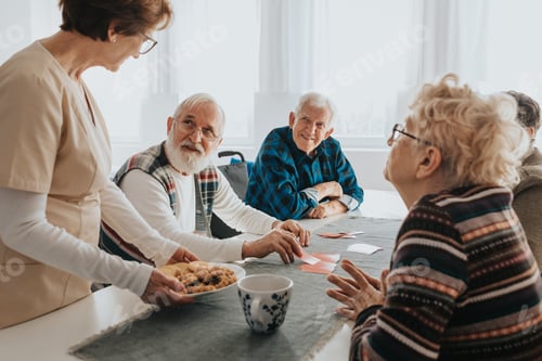 Preview: Seniors Playing Cards and Enjoying Cookies Indoors