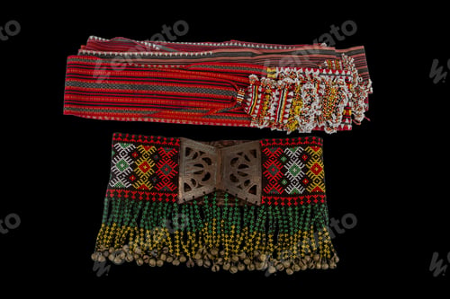 Preview: Closeup of old folded clothes with stripes isolated on a black background