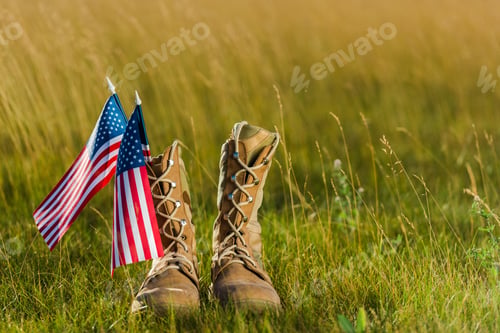 Preview: military boots near american flag with stars and stripes on grass