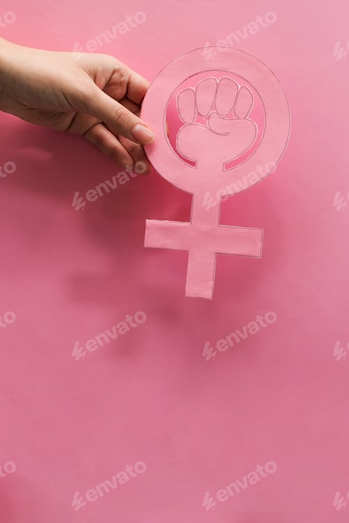 Preview: Vertical shot of a hand holding symbol of a woman's power - feminism concept