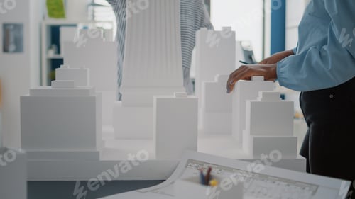 Preview: Close up of women with building model and blueprints plan on table