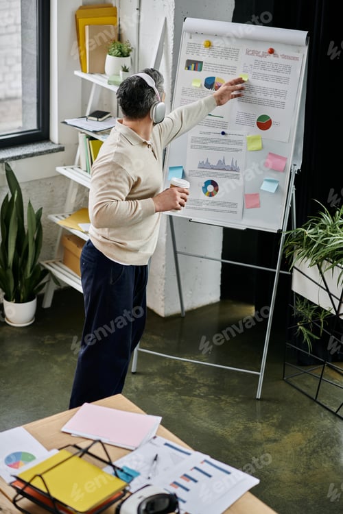 Preview: Bearded businessman analyzing charts in modern office