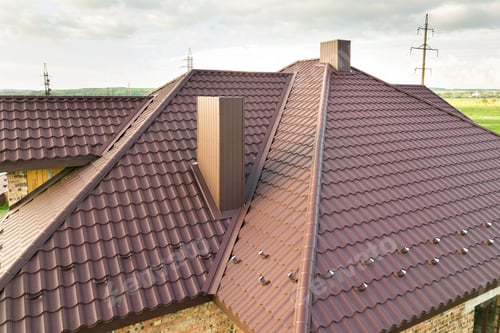 Preview: Detail view of house rooftop covered with brown metal tile sheets