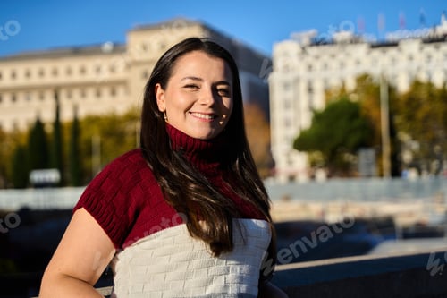 Preview: Young woman smiling in city park enjoying sunshine