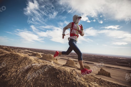 Preview: Woman trail runner cross country running on sand desert dunes