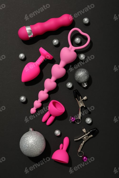 Preview: Sex toys with Christmas decorations on a dark background.