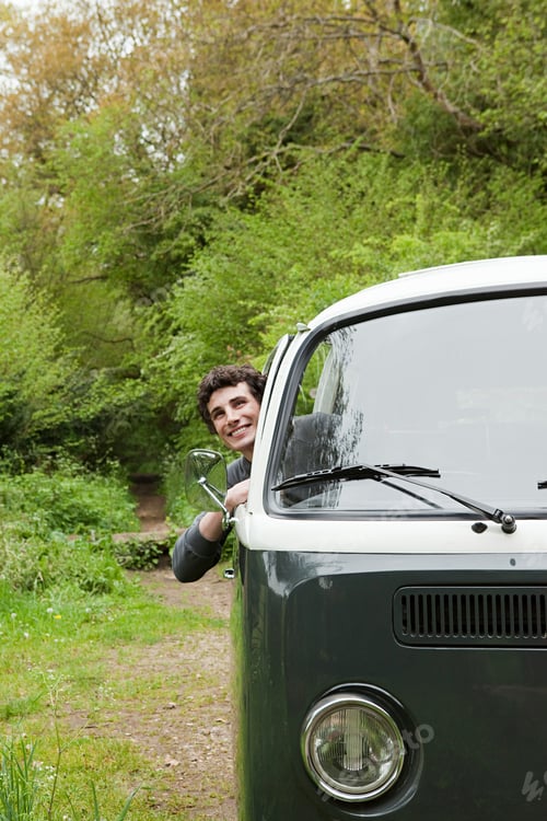 Preview: Smiling person enjoying a road trip in a vintage van