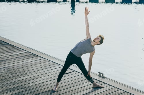 Preview: Man Practicing Yoga on Wooden Dock by Water