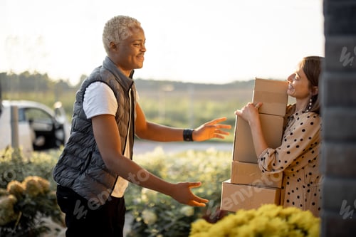 Preview: Delivery man giving parcels to caucasian woman