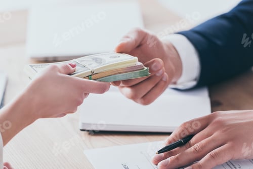 Preview: cropped shot of manager taking money from customer in office